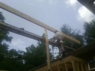 Carpenter setting a ridge beam over a new addition frame — Ice Dam Removal by Roofing Brothers in Excelsior Springs