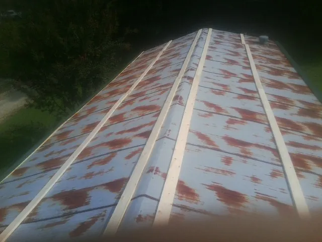 Rusted metal roof panels with new wood purlins before replacement — Storm Damage Roof Repair in Excelsior Springs by Roofing Brothers