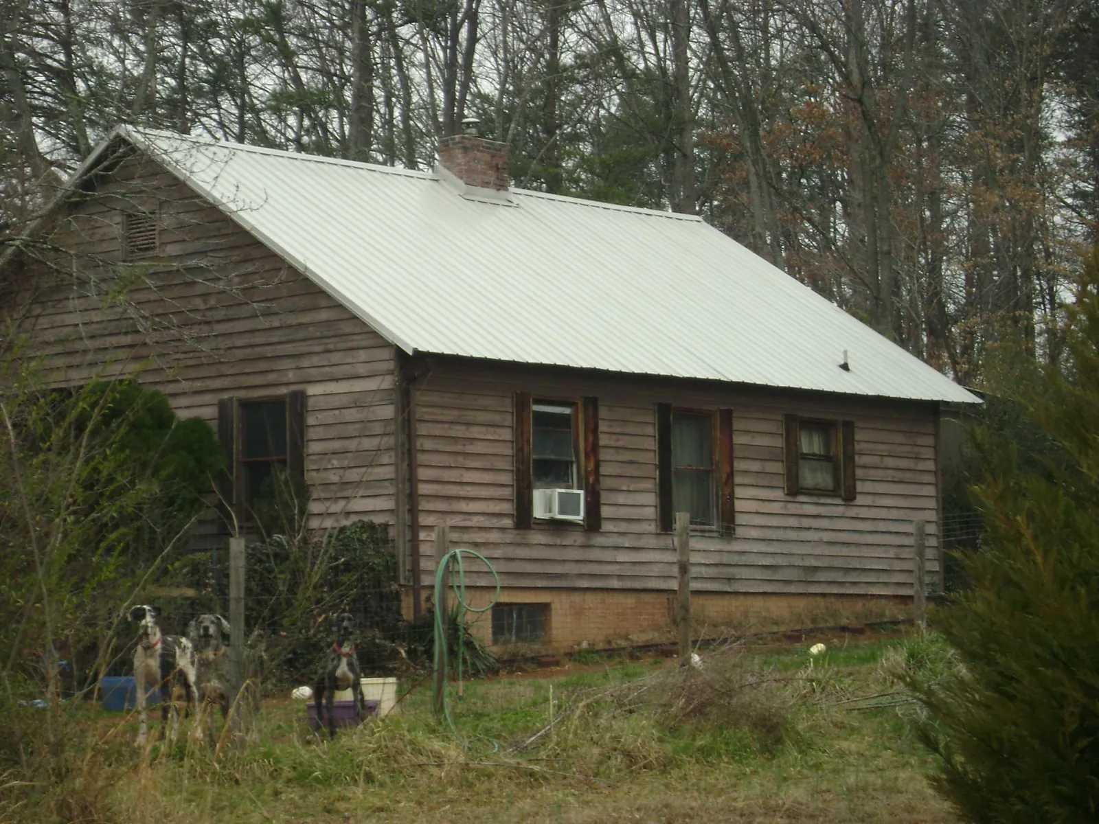 White metal roof on an old wood sided farmhouse, from a Metal Roof Installation job in Excelsior Springs